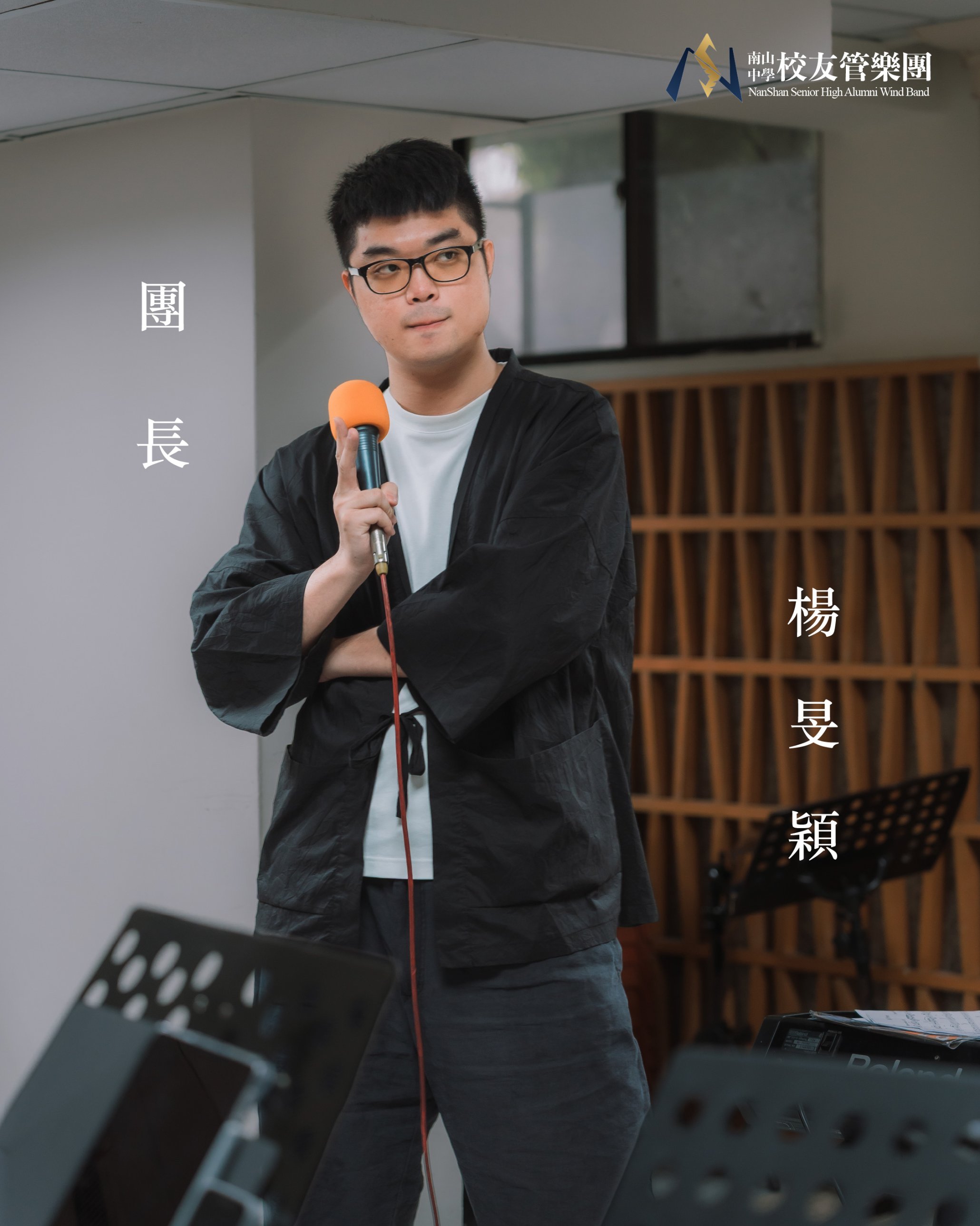團長楊旻穎拿著麥克風站在團練室